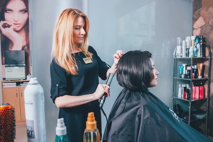 specialista v kosmetickém salonu dělá účes